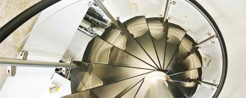 looking down on black wooden steps of a spiral staircase