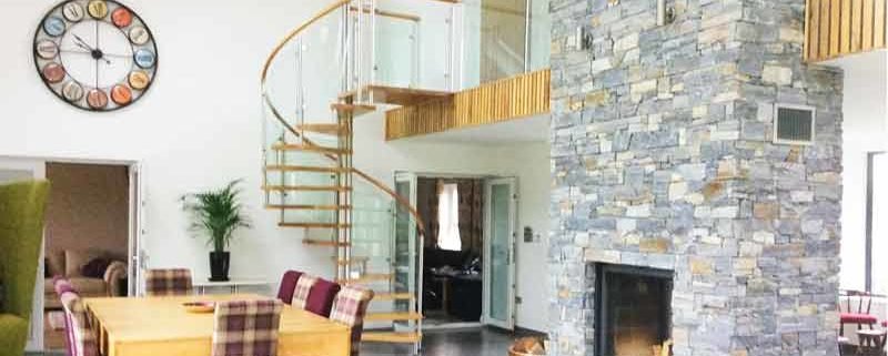 large dining and living space with dining table and glass and oak spiral staircase