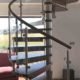 dark wood spiral stair Infront of window showing countryside