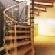 oak step spiral staircase with curved glass panels in a living area