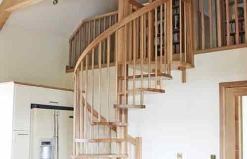 solid oak spiral stair leading upto a mezzanine level within a kitchen