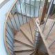 oak tread spiral staircase set within a circular opening with stainless spindles