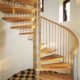 spiral staircase set within a curved wall with checked floor below