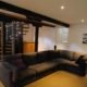 large living room with big black sofa Infront of spiral staircase