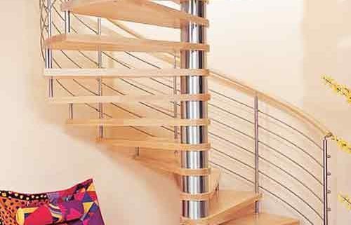 large light wood spiral staircase in a house with stainless steel horizontal bars