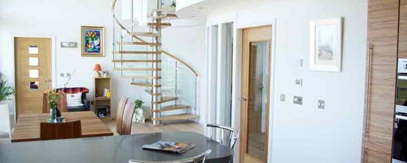 kitchen diner with breakfast bar and glass and oak spiral staircase