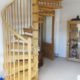 solid oak spiral staircase with timber spindles in a living room
