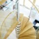 looking down on an oak spiral staircase with curved glass panels