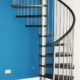 black timber spiral stair with stainless steel balustrade with blue wall behind