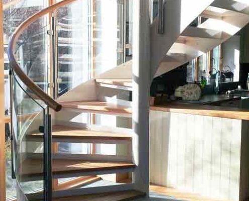 white steel and glass spiral stair in front of window