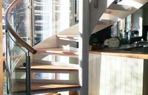 white steel and glass spiral stair in front of window
