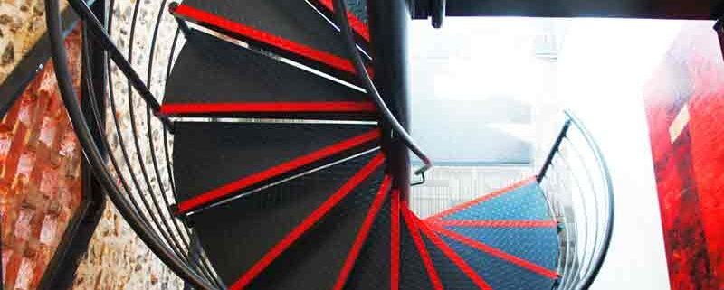 black steel spiral stair with red painted nosing