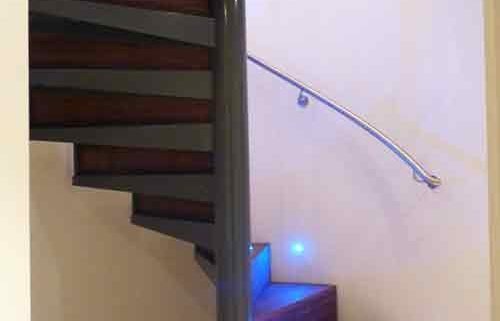 spiral stair enclosed by a curved wall with timber and steel