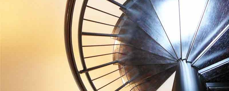 looking down on dark wood steps of a spiral stair