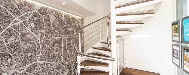 spiral stair in an estate agents in white and walnut