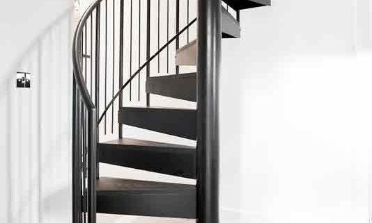 small black spiral staircase with light grey floor below