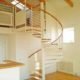 White spiral staircase with oak steps and handrail leading to mezzanine