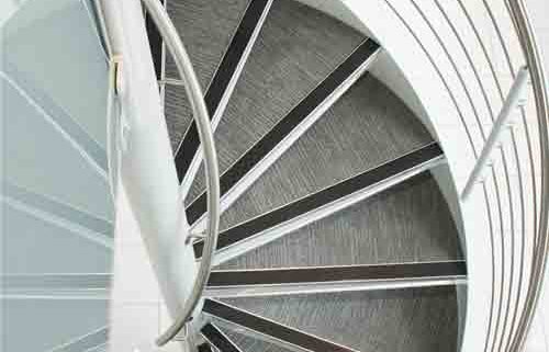 spiral stair with carpeted steps and steel column