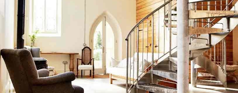 internal galvanised steel spiral stair with chair and sofa on view