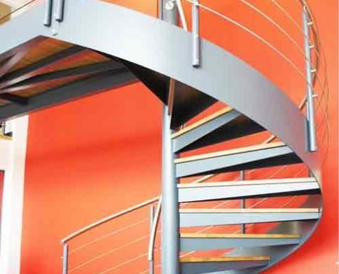 large commercial spiral staircase with large red wall behind