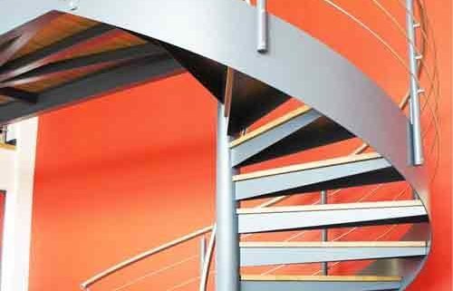 large commercial spiral staircase with large red wall behind