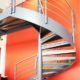 large commercial spiral staircase with large red wall behind