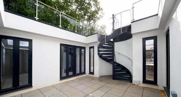 dark grey spiral stair in a courtyard
