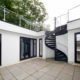 dark grey spiral stair in a courtyard