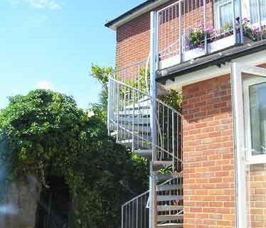 external spiral stair leading upto a balcony to the rear of a house