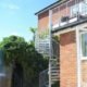 external spiral stair leading upto a balcony to the rear of a house