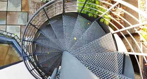 perforated grey steel steps on a spiral stair outside