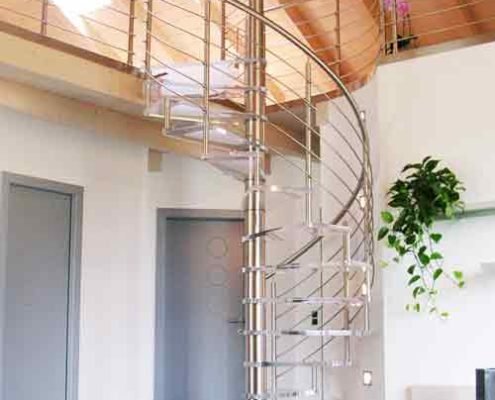 acrylic spiral staircase leading upto a mezzanine level with highly polished floor below
