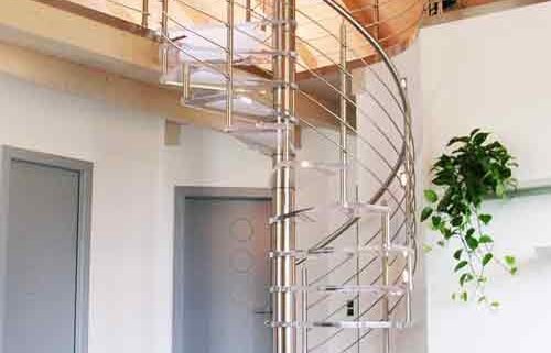acrylic spiral staircase leading upto a mezzanine level with highly polished floor below
