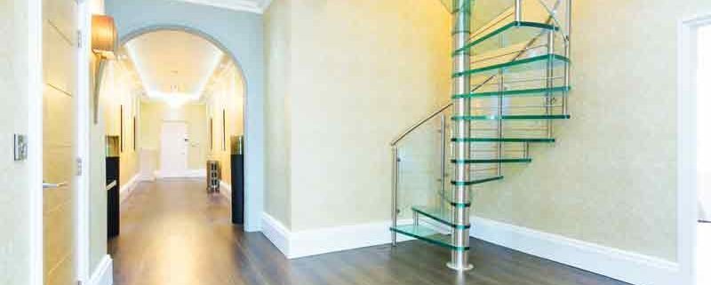 glass spiral staircase in a large hallway