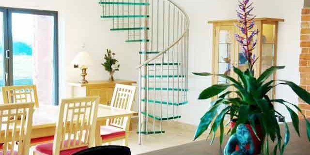 modern living space with table and glass spiral stair