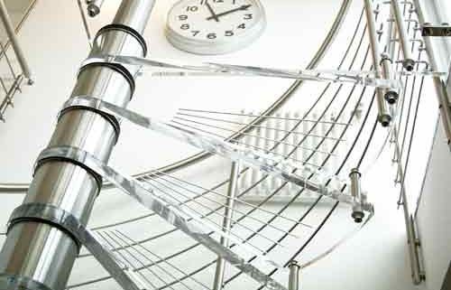 top transparent platform of a spiral stair with clock on wall