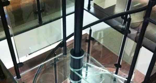 square glass platform at the top of a spiral stair with black balustrade