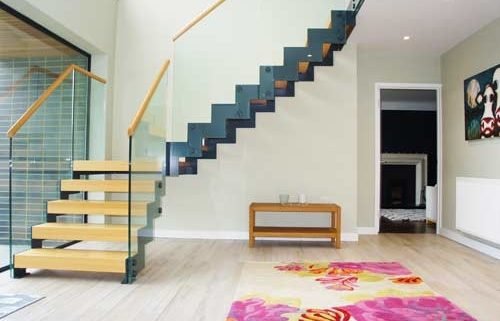 hallway with grey steel and wood staircase