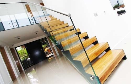 glass sides to a modern open riser stair in a hallway