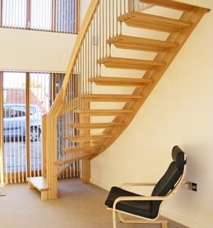 hallway with black chair and a quarter turn staircase
