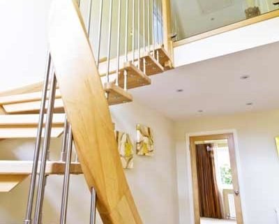 curved handrail on a light and open wooden stair