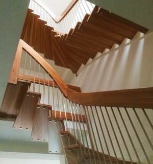 looking up at a double flight floating wooden staircase