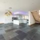 large grey tiled living area with kitchen and modern stair on show