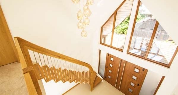 double height hallway with floating stair running up against a wall