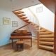 curved wooden staircase with piano