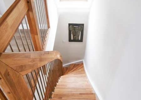 looking down a wooden staircase with landing balustrade