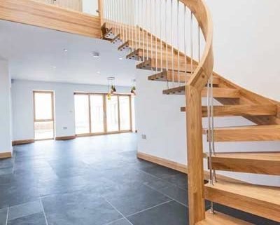 grey tiles floor with floating style oak staircase leading up