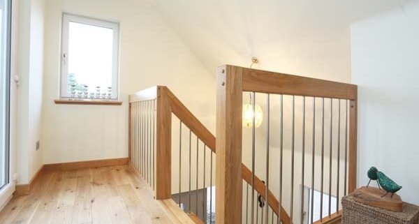 landing balustrade with oak handrail and stainless steel spindles
