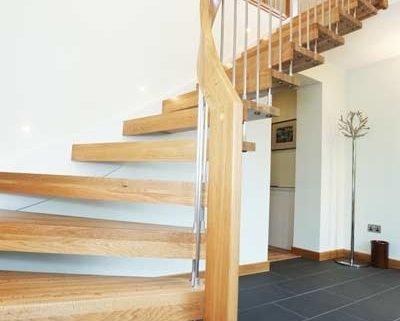 grey tiled floor in hallway with a quarter turn light oak staircase