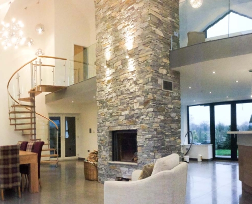 large living space showing table and chairs and mezzanine with a spiral staircase